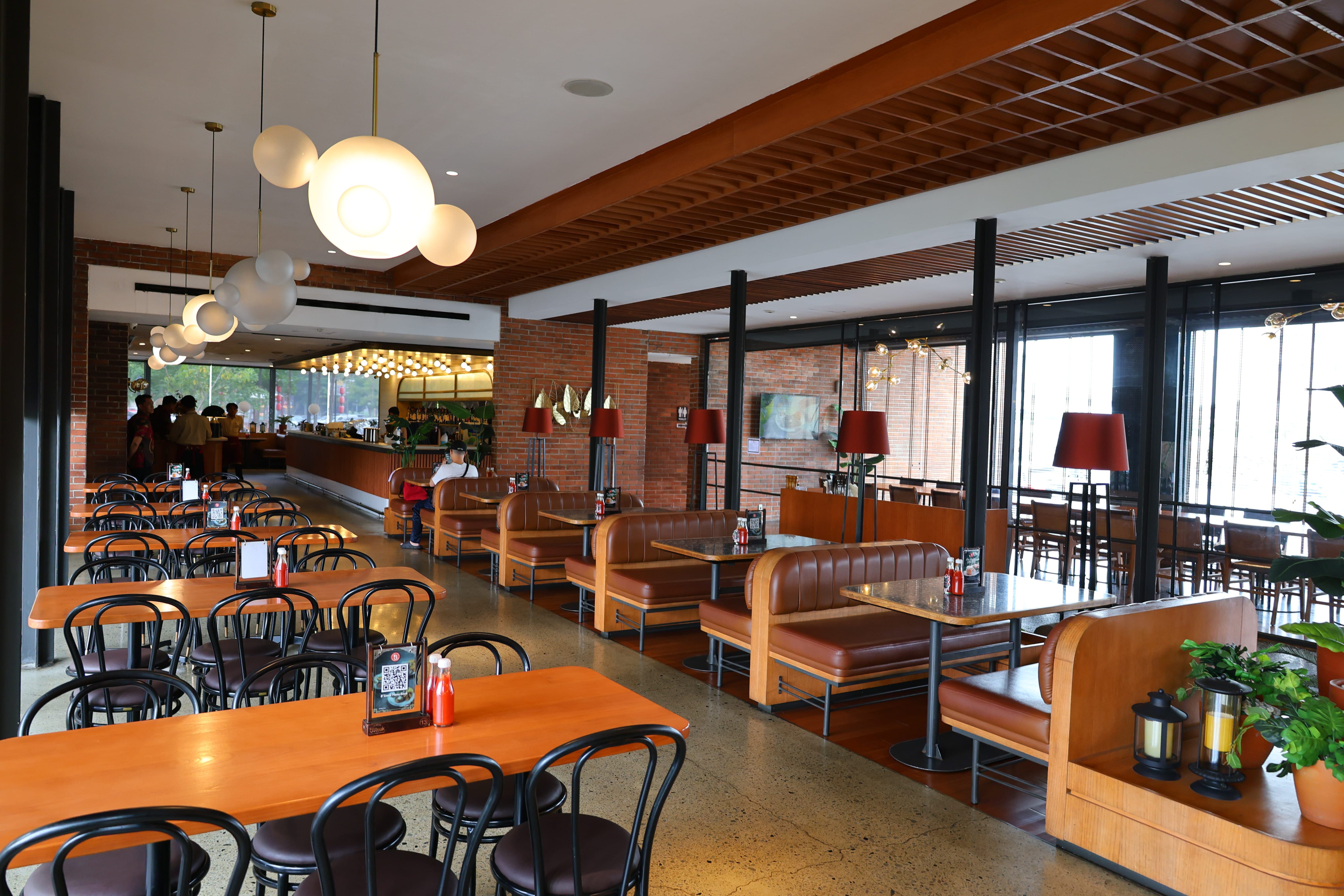 BSteak Kelapa Gading dining floor with solid wood tables, leather booth frames, and timber beam ceiling by Reywood
